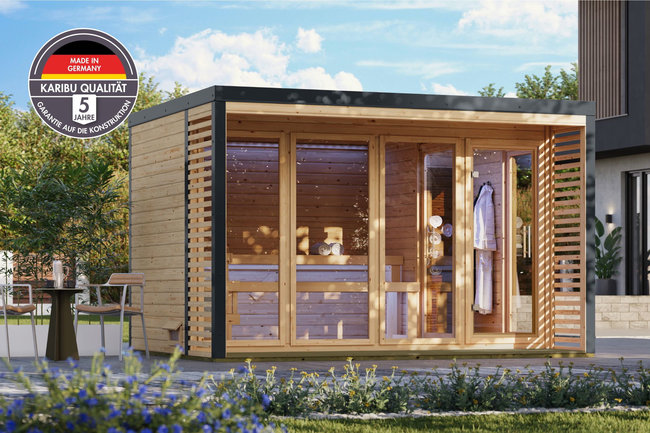 Karibu Saunahaus Ares 4 als Gartensauna aus Massivholz im Garten mit Glasfront